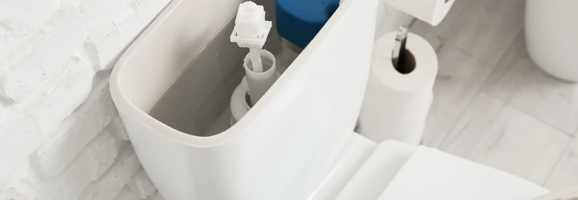 Blick in den geöffneten Spülkasten einer Toilette mit sichtbarem Innenleben.